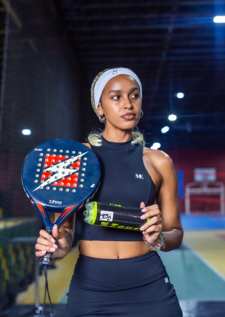 Joueuse de padel raquette et balle en main sur un court couvert